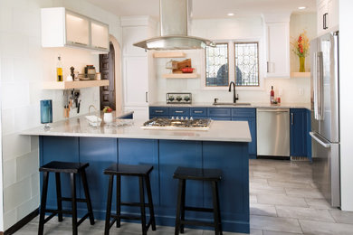 Mid-sized country l-shaped porcelain tile and gray floor eat-in kitchen photo in Wichita with an undermount sink, flat-panel cabinets, blue cabinets, quartz countertops, white backsplash, glass tile backsplash, stainless steel appliances, a peninsula and gray countertops