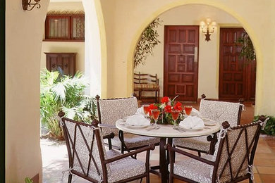 Large tuscan backyard tile patio photo in Miami with a roof extension