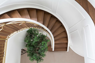 Inspiration for a transitional wood curved staircase in Calgary with wood risers and metal railing.