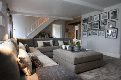 Trendy enclosed carpeted living room photo in New York with white walls, a standard fireplace, a wood fireplace surround and a media wall