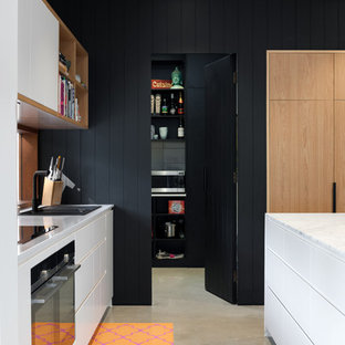 Idées déco pour une arrière-cuisine parallèle scandinave de taille moyenne avec un évier posé, un plan de travail en quartz modifié, une crédence en fenêtre, un électroménager noir, béton au sol et un îlot central.