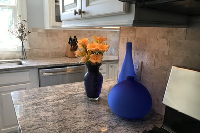 Kitchen pantry - small traditional l-shaped laminate floor and brown floor kitchen pantry idea in Baltimore with an undermount sink, raised-panel cabinets, white cabinets, granite countertops, multicolored backsplash, marble backsplash, stainless steel appliances, no island and multicolored countertops