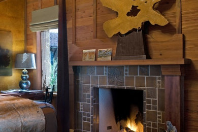 Inspiration for a mid-sized country bedroom in San Francisco with brown walls, slate floors, a standard fireplace and a tile fireplace surround.