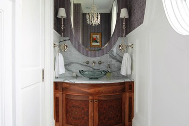 This is an example of a small traditional powder room in Boston with furniture-like cabinets, dark wood cabinets, a two-piece toilet, purple walls, marble floors, a vessel sink, marble benchtops and white floor.