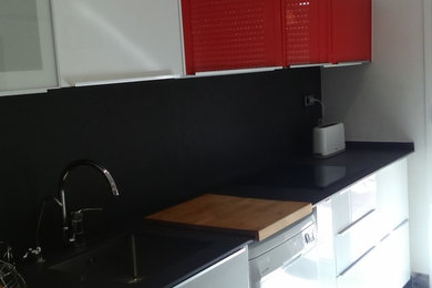 Foto de cocina lineal actual de tamaño medio sin isla con armarios con paneles lisos, puertas de armario blancas y salpicadero negro