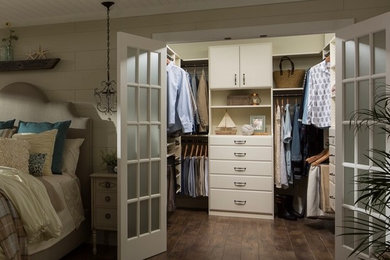 Inspiration for a mid-sized cottage master brown floor and medium tone wood floor bedroom remodel in Miami with beige walls and no fireplace