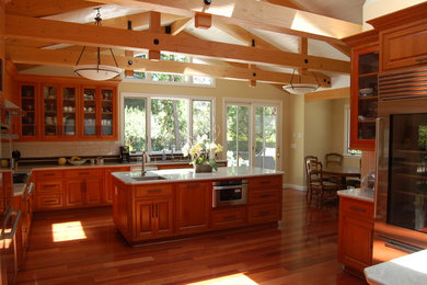 Example of a huge arts and crafts dark wood floor open concept kitchen design in San Francisco with recessed-panel cabinets, medium tone wood cabinets, quartz countertops, white backsplash, ceramic backsplash, stainless steel appliances, an island and an undermount sink