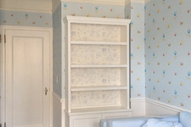 Mid-sized elegant boy carpeted nursery photo in New York with blue walls