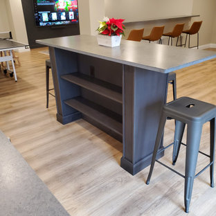 Idées déco pour un grand sous-sol classique donnant sur l'extérieur avec un bar de salon, un mur beige, sol en stratifié, un sol marron et du lambris de bois.