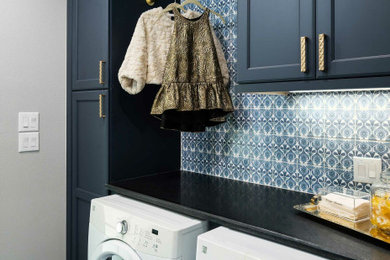 Inspiration for a mid-sized craftsman single-wall ceramic tile and blue floor dedicated laundry room remodel in Dallas with shaker cabinets, blue cabinets, soapstone countertops, blue backsplash, porcelain backsplash, gray walls, a side-by-side washer/dryer and black countertops
