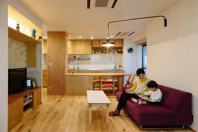 Example of a small danish formal and open concept medium tone wood floor living room design in Tokyo with white walls
