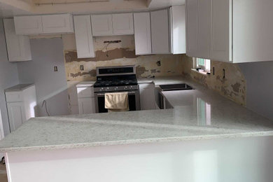 Example of a mid-sized classic u-shaped eat-in kitchen design in Salt Lake City with a farmhouse sink, shaker cabinets, white cabinets, quartzite countertops, a peninsula and multicolored countertops