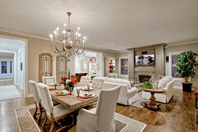 This is an example of a large transitional open plan dining in Chicago with beige walls, medium hardwood floors, a standard fireplace and a stone fireplace surround.