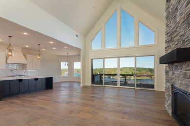 Mid-sized transitional l-shaped dark wood floor and brown floor open concept kitchen photo in Other with an undermount sink, shaker cabinets, white cabinets, solid surface countertops, white backsplash, subway tile backsplash, stainless steel appliances and an island