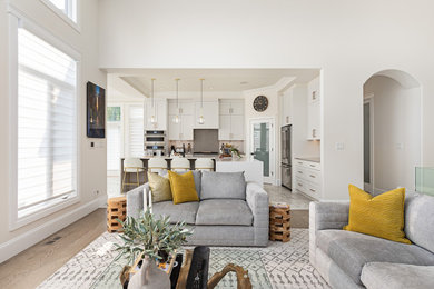 Esempio di un grande soggiorno aperto con pareti bianche, pavimento marrone e pavimento in legno massello medio
