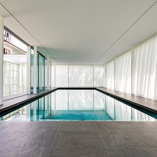 Moderner Indoor-Pool in rechteckiger Form mit Natursteinplatten in München