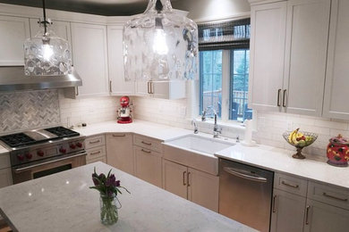 Transitional light wood floor open concept kitchen photo in Other with a farmhouse sink, recessed-panel cabinets, white cabinets, white backsplash, subway tile backsplash, stainless steel appliances, an island and white countertops