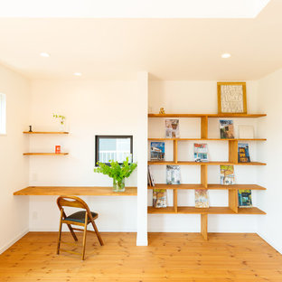 他の地域のモダンスタイルのおしゃれなホームオフィス・仕事部屋 (白い壁、無垢フローリング、造り付け机、茶色い床) の写真