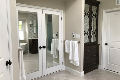Bathroom - mid-sized traditional master white tile and subway tile porcelain tile and beige floor bathroom idea in DC Metro with flat-panel cabinets, brown cabinets, gray walls, an undermount sink, quartz countertops and a hinged shower door