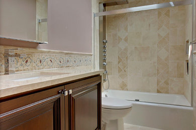 Inspiration for a mid-sized transitional 3/4 beige tile and ceramic tile ceramic tile bathroom remodel in Seattle with raised-panel cabinets, dark wood cabinets, a two-piece toilet, gray walls, an undermount sink and marble countertops