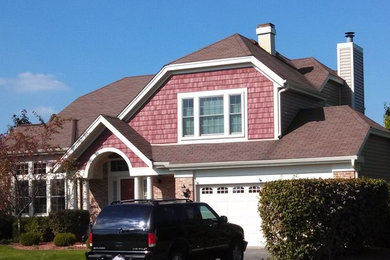Inspiration for a large timeless red two-story mixed siding exterior home remodel in Chicago with a gambrel roof