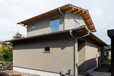 Ejemplo de fachada de casa gris de dos plantas con tejado a dos aguas