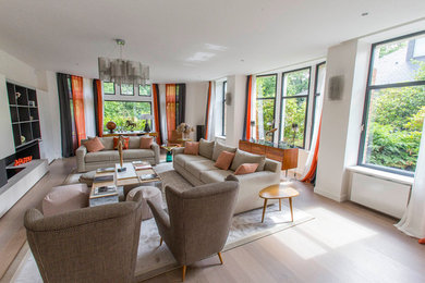 Idées déco pour un grand salon blanc et bois moderne ouvert avec un mur blanc, parquet clair, un manteau de cheminée en bois, aucun téléviseur, aucune cheminée, un sol marron et éclairage.