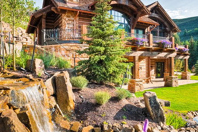 This is an example of a large rustic partial sun hillside stone landscaping in Denver for summer.