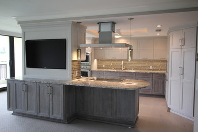 Large elegant galley porcelain tile and beige floor eat-in kitchen photo in Miami with an undermount sink, flat-panel cabinets, white cabinets, granite countertops, beige backsplash, subway tile backsplash, stainless steel appliances and an island
