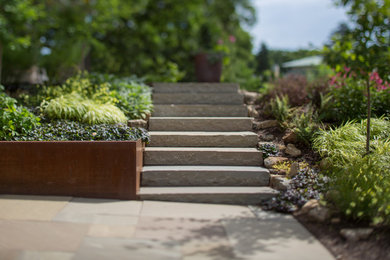 Photo of a contemporary full sun front yard stone retaining wall landscape in Minneapolis.