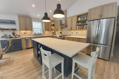 Example of a mid-sized farmhouse l-shaped vinyl floor, beige floor and vaulted ceiling open concept kitchen design in Ottawa with an undermount sink, shaker cabinets, blue cabinets, multicolored backsplash, porcelain backsplash, stainless steel appliances, an island, white countertops and quartz countertops