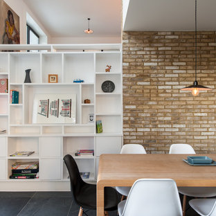 Cette image montre une salle à manger design avec un mur blanc et un sol en ardoise.