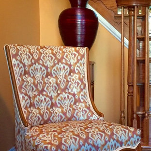 Bild på en mellanstor eklektisk foajé, med orange väggar och mörkt trägolv