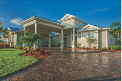 Mid-sized tropical beige two-story wood house exterior idea in Orlando with a hip roof and a metal roof