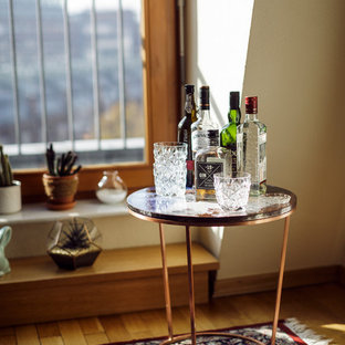 Esempio di un piccolo soggiorno chic aperto con pareti beige, angolo bar, parquet chiaro, nessun camino e nessuna TV