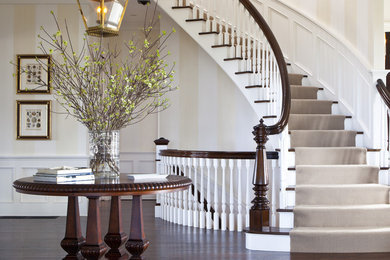 Large traditional wood curved staircase in Boston with painted wood risers.