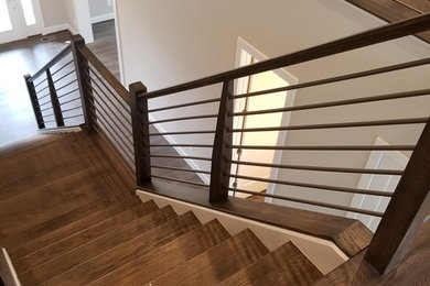 Imagen de escalera recta clásica renovada grande con escalones de madera, contrahuellas de madera y barandilla de varios materiales