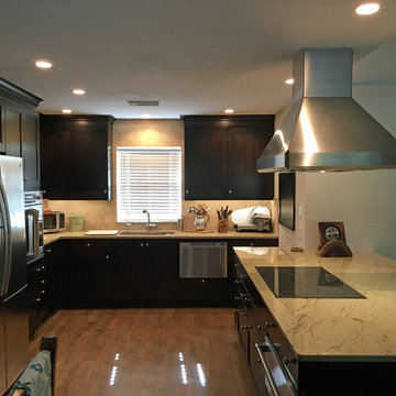 Open concept kitchen features dark wood cabinets and yet is light and bright