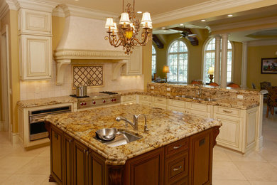 Mid-sized elegant l-shaped ceramic tile open concept kitchen photo in Chicago with raised-panel cabinets, white cabinets, granite countertops, beige backsplash, ceramic backsplash, stainless steel appliances and an island