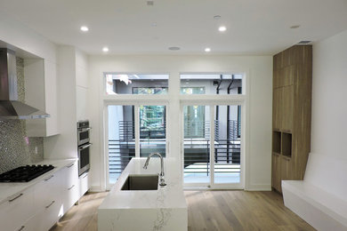 Eat-in kitchen - modern light wood floor eat-in kitchen idea in Philadelphia with a single-bowl sink, flat-panel cabinets, quartz countertops, mosaic tile backsplash, stainless steel appliances and an island