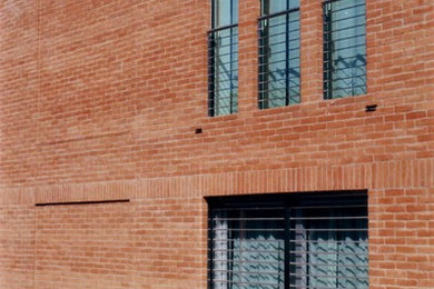 Esempio della facciata di una casa grande contemporanea a due piani con rivestimento in mattoni e copertura in metallo o lamiera