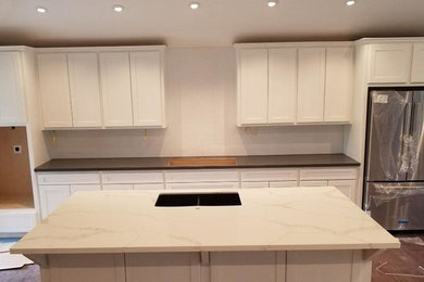 Example of a mid-sized trendy single-wall medium tone wood floor and brown floor eat-in kitchen design in Houston with an undermount sink, shaker cabinets, white cabinets, quartz countertops, white backsplash, subway tile backsplash, stainless steel appliances and an island