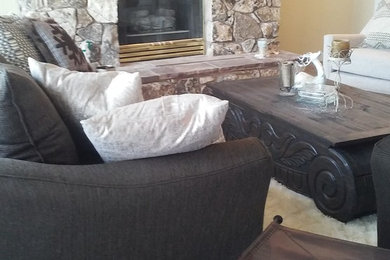 Example of a large mountain style formal and enclosed medium tone wood floor and gray floor living room design in Other with beige walls, a standard fireplace, a stone fireplace and no tv