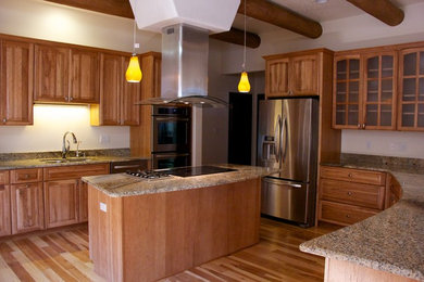 Mid-sized tuscan u-shaped medium tone wood floor kitchen photo in Albuquerque with an undermount sink, shaker cabinets, medium tone wood cabinets, granite countertops, stainless steel appliances and an island