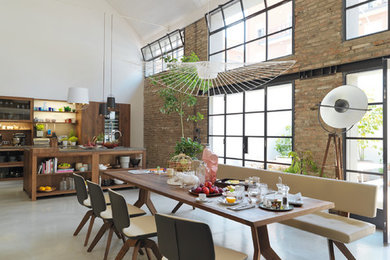 Geräumiges, Offenes Industrial Esszimmer ohne Kamin mit weißer Wandfarbe, Betonboden und grauem Boden in Hannover