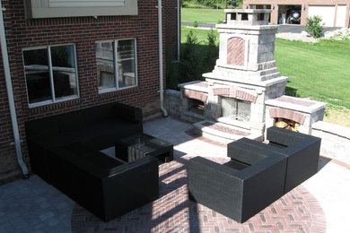 This is an example of an arts and crafts backyard patio in Detroit with a fire feature and brick pavers.