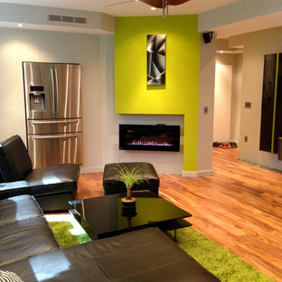 Design ideas for a contemporary basement in Atlanta with green walls, medium hardwood flooring, a ribbon fireplace and orange floors.