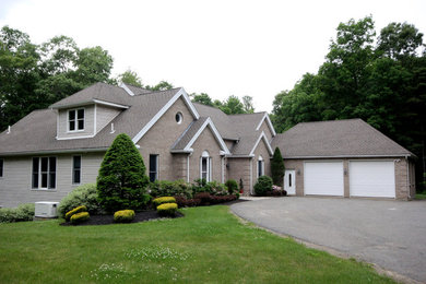 Inspiration for a large timeless beige split-level mixed siding exterior home remodel in Orange County with a shingle roof