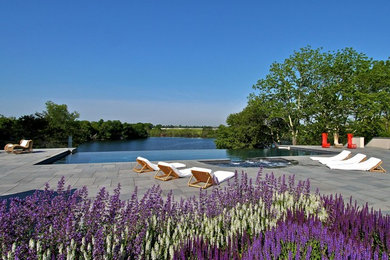 Inspiration for a large timeless backyard concrete paver and rectangular infinity hot tub remodel in New York