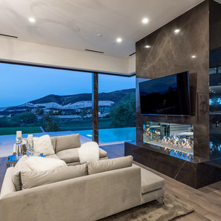 Großes Modernes Hauptschlafzimmer mit gefliester Kaminumrandung, weißer Wandfarbe, dunklem Holzboden, Gaskamin und braunem Boden in Las Vegas